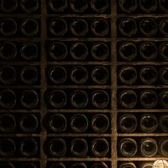 Botellas tumbadas en un botellero de bodega de piedra