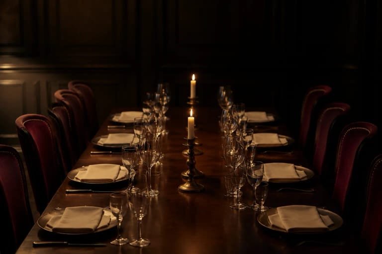 A private dining table set with crystal glasses and candles for a wine dinner