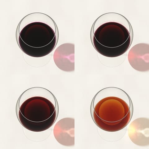Four glasses of red wine from young purple to mature tawny, seen from above