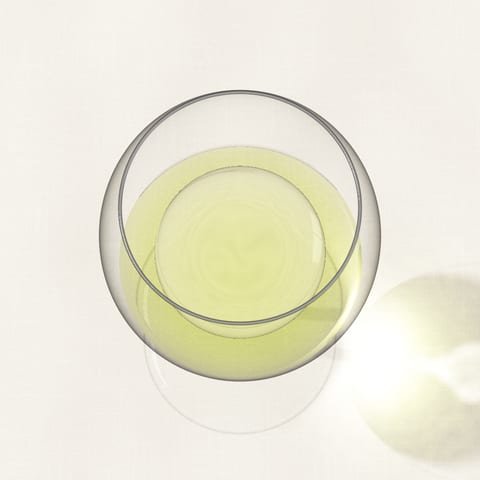 A glass of pale lemon white wine seen from above on a linen cloth