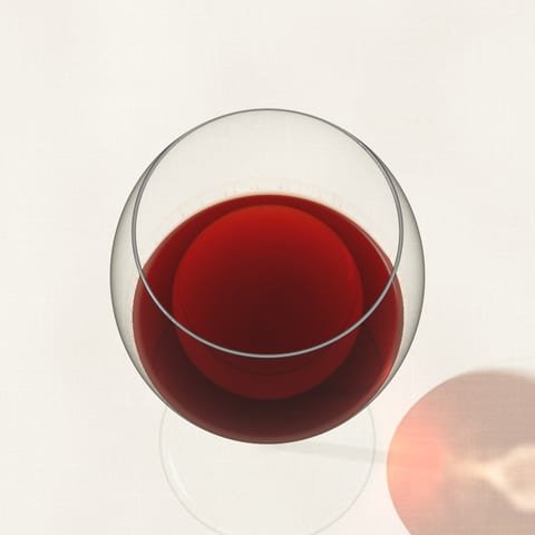 Pale garnet Nebbiolo with an orange rim, seen from above on a linen cloth