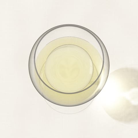 A glass of pale white wine seen from above on a linen cloth