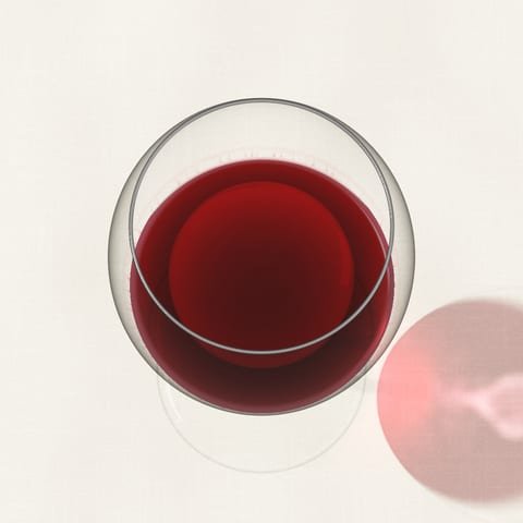 A glass of light ruby Pinot Noir seen from above on a linen cloth