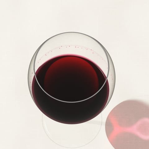 Un verre de vin rouge qu'on vient de faire tourner, vu du dessus sur une nappe de lin