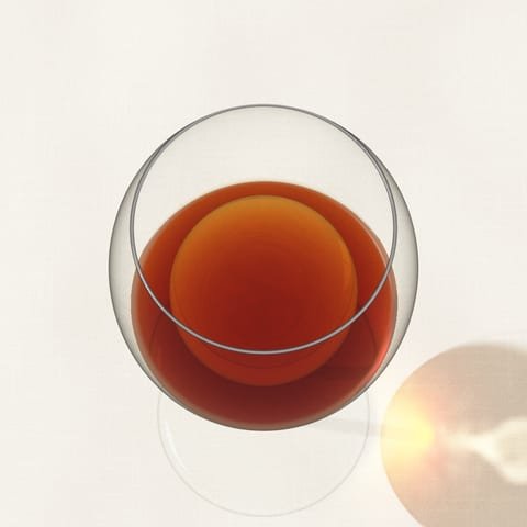 A glass of amber-brown tawny Port, seen from above on a linen cloth